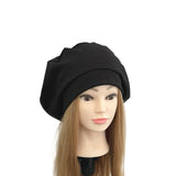 Mannequin head with long blonde hair wearing a black beanie on a white background