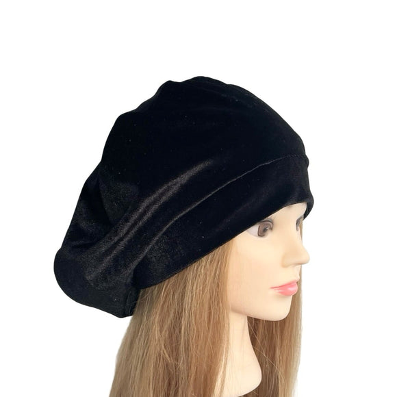 Black beret on a mannequin head with long hair against a white background