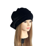 Black hat on a mannequin head with long hair against a white background