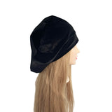 Black beret on a mannequin head with long blonde hair against a white background
