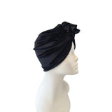 Black turban on a mannequin head against a white background