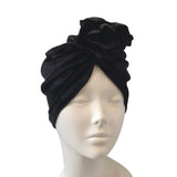 Black turban with floral design on a mannequin head against a white background