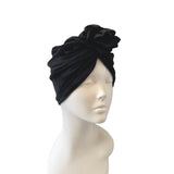 Black headscarf with floral design on a mannequin head against a white background