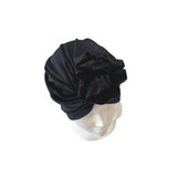 Black turban on a mannequin head against a white background