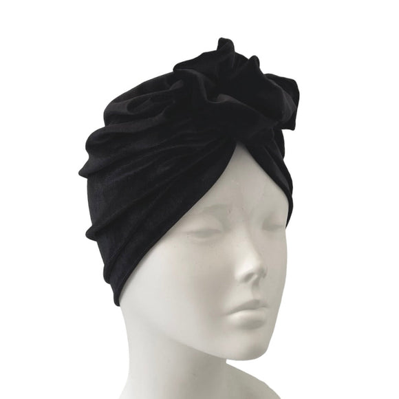 Black turban on a mannequin head against a white background