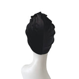 Black turban on a mannequin head against a white background