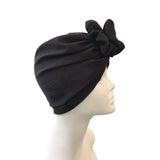 Black turban with a decorative bow on a mannequin head against a white background