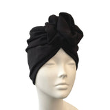 Black turban on a mannequin head against a white background