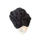 Black turban on a mannequin head against a white background