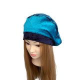 Blue satin hair bonnet on a mannequin head with brown hair against a white background