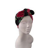 A multicolor patterned headwrap turban hat styled on a white mannequin head, shown against a plain white background.