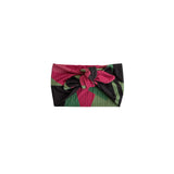 A fabric headband with a large bow, featuring a geometric pattern of pink, green, and black stripes.