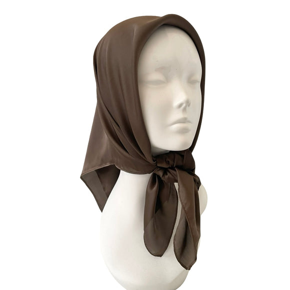 Brown headscarf on a mannequin head against a white background