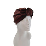 Brown turban with a bow on a mannequin head against a white background