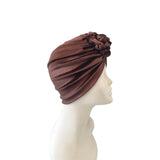 Brown turban on a mannequin head against a white background
