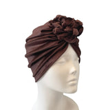 Brown turban on a mannequin head against a white background
