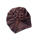 Brown satin hair turban with a flower on a white background