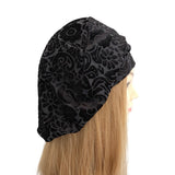 Black patterned headscarf on a mannequin head with long blonde hair against a white background