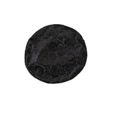 Black floral-patterned round object on a white background