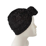 Black lace headband on a mannequin head against a white background
