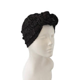 Black textured headband with floral design on a mannequin head against a white background