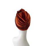 Brown turban on a white mannequin head against a white background