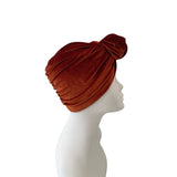 Brown turban on a mannequin head against a white background