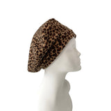 Leopard print beret on a mannequin head against a white background