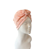 Pink textured headscarf on a mannequin head against a white background