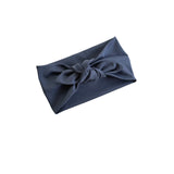 A dark navy blue fabric gift wrap or pouch with a knotted bow detail, shown on a plain white background.