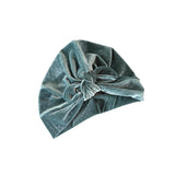 Green velvet turban with a knot on a white background