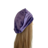 Purple velvet headband on a mannequin head with blonde hair against a white background