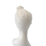 White lace headband on a mannequin head against a white background