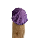 Purple velvet headband on a mannequin head with blonde hair against a white background