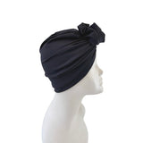 Navy blue headscarf with a bow on a mannequin head against a white background