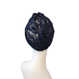 Navy blue lace headscarf on a mannequin head against a white background