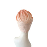 Mannequin head with a pink textured wig on a white background