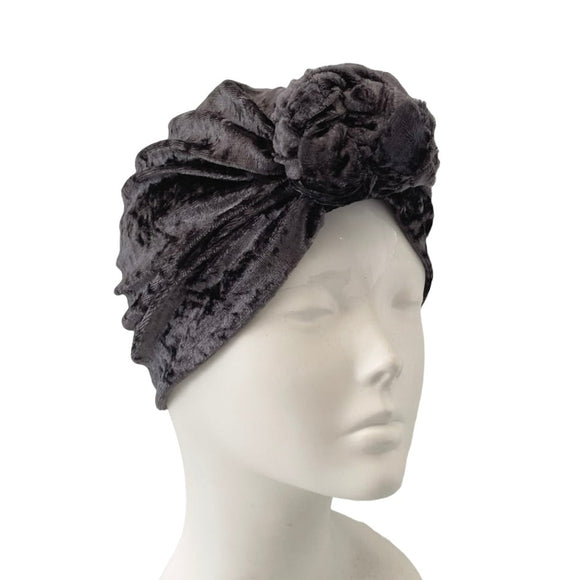 Dark gray headband with floral design on a mannequin head against a white background