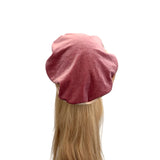 Pink beret on a mannequin head with blonde hair against a white background