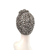 Leopard print headscarf on a mannequin head against a white background
