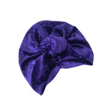 Purple velvet turban with a bow on a white background
