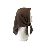 Brown headscarf tied on a mannequin head against a white background