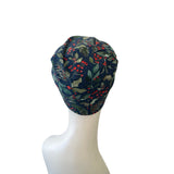 Navy blue scrub cap with floral pattern on a mannequin head against a white background