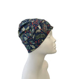 Navy blue headscarf with nature-themed print on a mannequin head against a white background