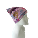 Pink headscarf with butterfly patterns on a mannequin head against a white background