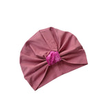 Pink turban with a decorative bow on a white background