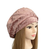 Mannequin head wearing a pink velvet beret on a white background