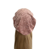 Pink velvet beret on a mannequin head with long blonde hair against a white background