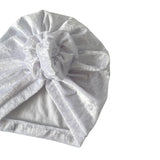 White textured towel with a knot on a white background