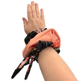 Hand wearing a colorful scrunchie on a white background ireland